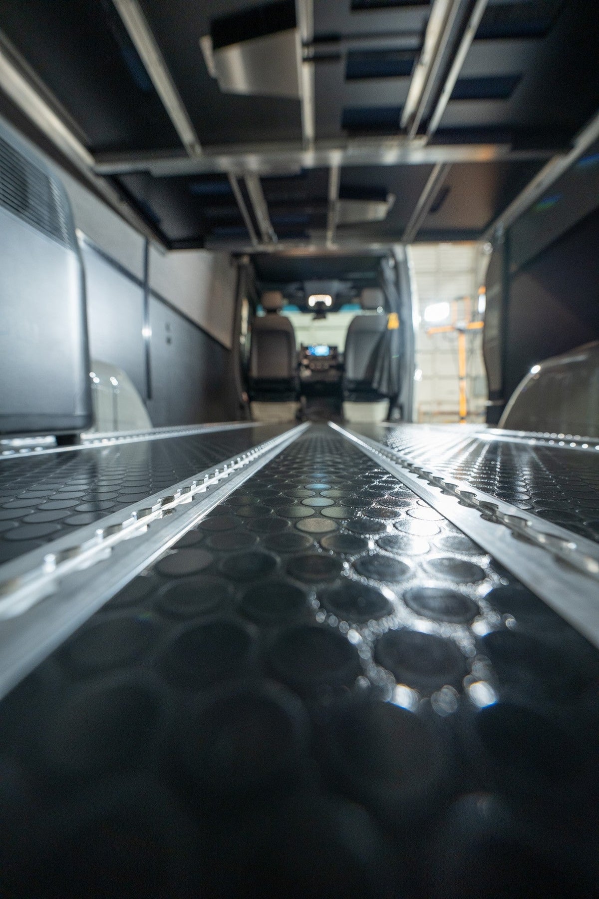 Close view along aluminum Smartfloor rails set into a black floor